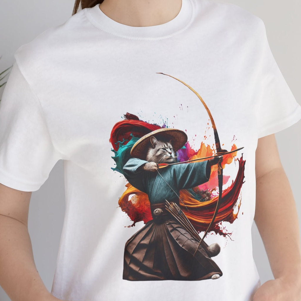 Person wearing a white t-shirt with a colorful graphic design, standing indoors next to a plant.