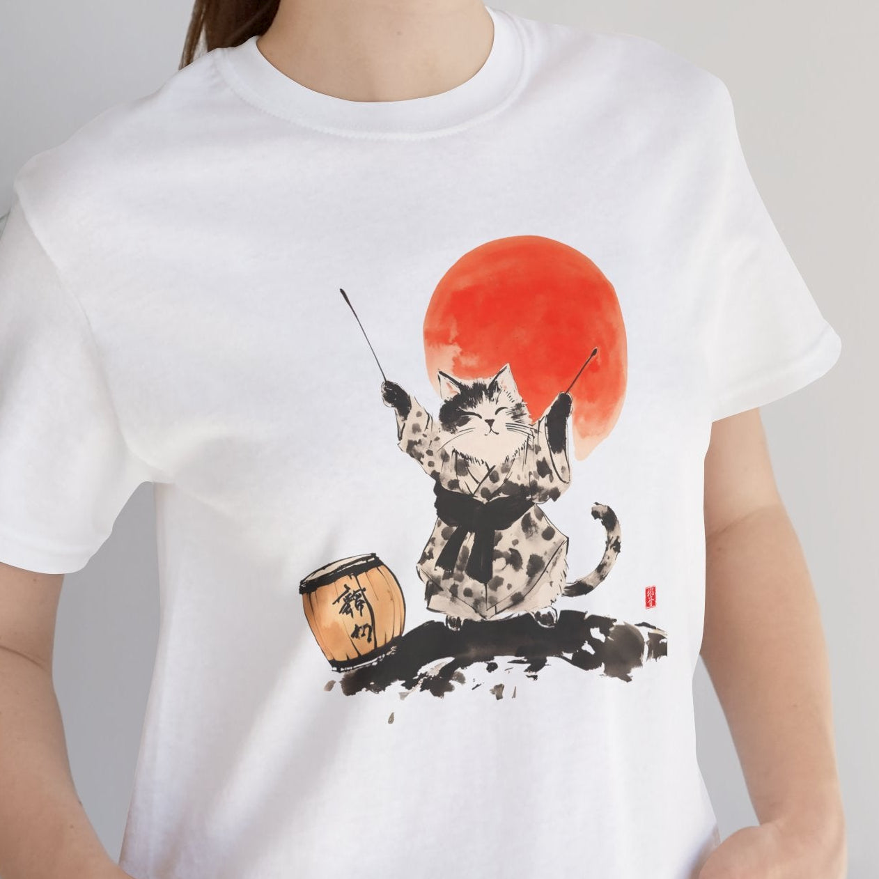 Person wearing a white t-shirt with a graphic design of a dog and a red sun, standing indoors.