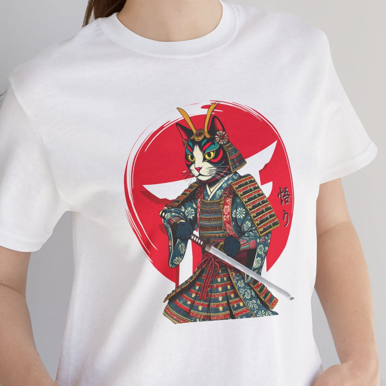 Person wearing a white t-shirt with a colorful graphic design of a cat in samurai attire.