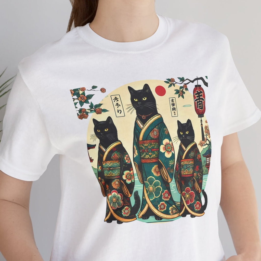 Person wearing a white t-shirt with a colorful design of three cats in traditional Japanese clothing.