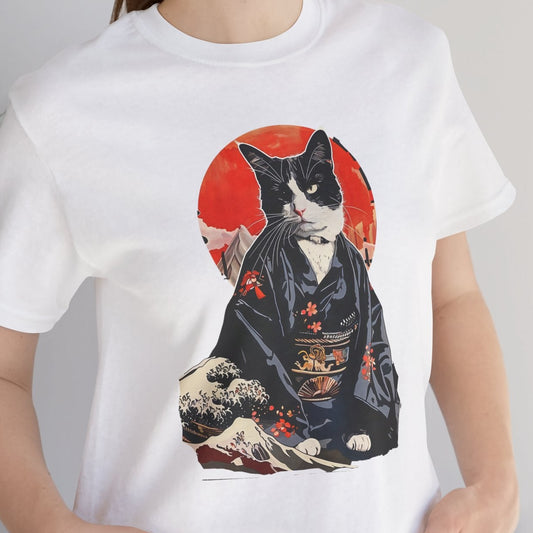 Person wearing a white t-shirt with a cat in a kimono design, standing indoors next to a plant.