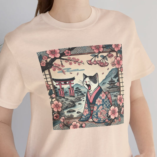 Person wearing a beige t-shirt with a graphic design of a cat in a kimono and cherry blossoms.