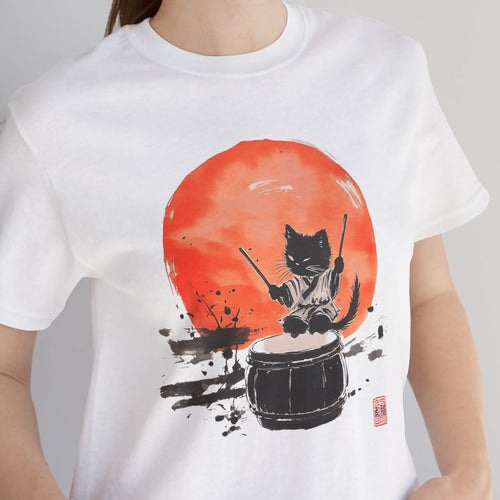 Person wearing a white t-shirt with a graphic design of a cat playing drums against an orange sun, standing indoors.