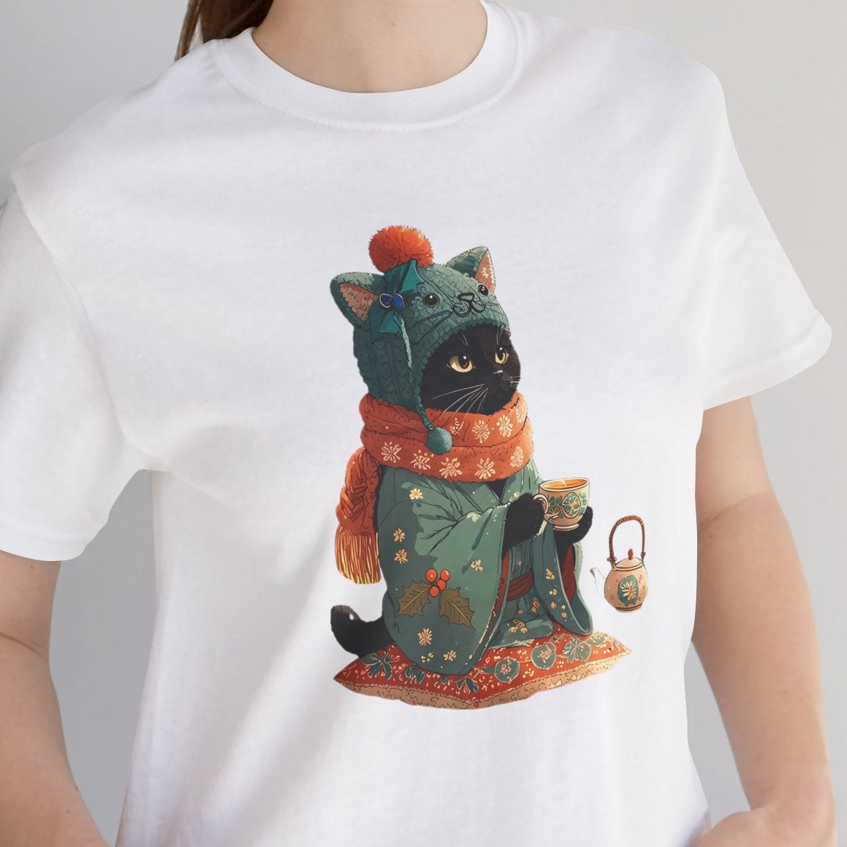 Person wearing a white t-shirt with a colorful cat graphic design, standing indoors next to a plant.