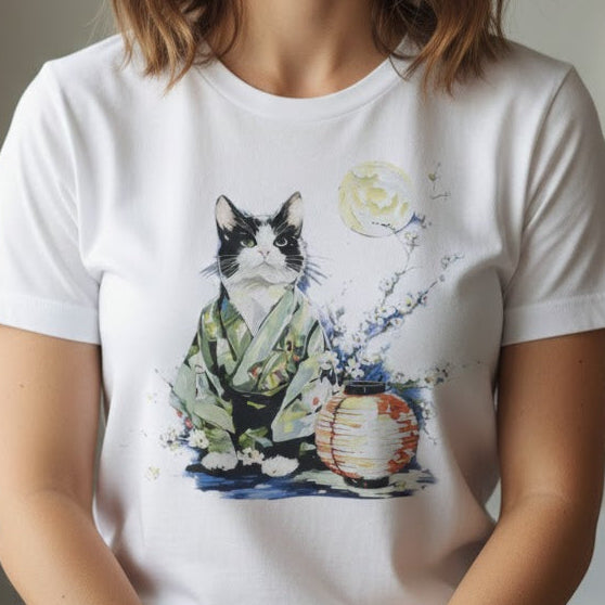 Woman wearing a white t-shirt with a cat and moon design in a room with natural light.
